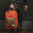 Filson Surveyor 25L Backpack Dark Tan/Flame carrying in hand