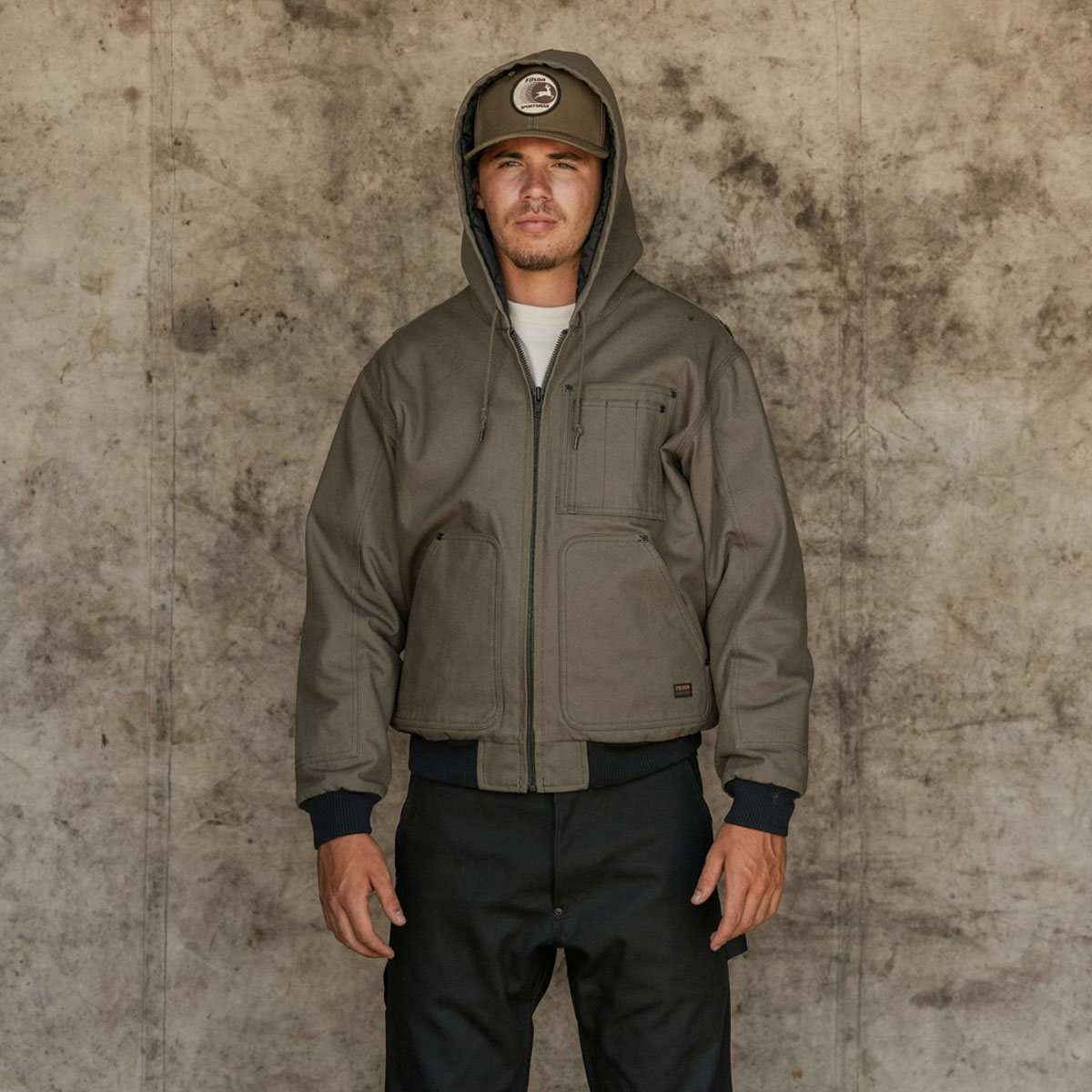 Filson Worksmith Insulated Bomber Jac Tarmac, mit durch Kordelzug verstellbarer Kapuze, die einen guten Sitz und zusätzlichen Schutz vor den Elementen bietet